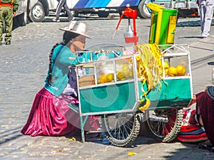 BOLIVIA, LA PAZ, 24 JULY 2008: Street orange juice woman seller with small carriage in La Paz, Bolivia, South America