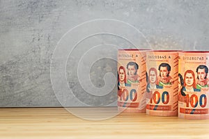 Bolivian currency, Rolls of money, 100 Boliviano banknotes lined up next to each other, Empty space for text