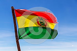 Bolivian Flag waving in the wind against blue sky background