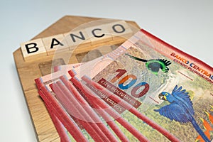 Bolivian money and the symbol of the bank of Colombia, a wooden miniature with the inscription banco, A lot of highest