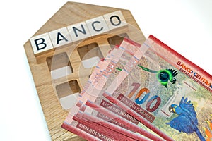 Bolivian money and the symbol of the bank of Colombia, a wooden miniature with the inscription banco, A lot of highest