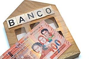 Bolivian money and the symbol of the bank of Colombia, a wooden miniature with the inscription banco, A lot of highest