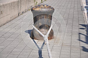 Bollard mooring leash. Ship attached with a thick rope to a bollard in the harbour. on the Bulbous bow of cargo ship