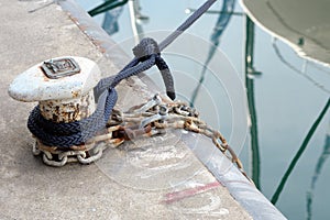 Bollard on a quay with mooring ropes