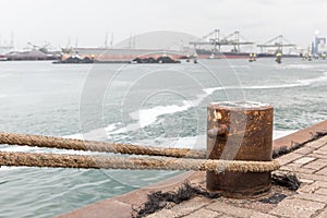 A bollard with rope on a quay in the harbor