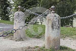 Bollard stone posts with metal chains and a lock in place