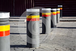 The bollards with reflective stripes.