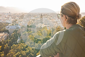 Bolnde female touris enjoying amazing panoramic aerial view of Malaga city historic center, Coste del Sol, Andalucia