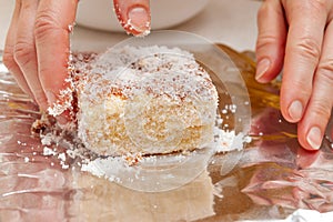 BOLO GELADO is a traditional Brazilian cake - Wrapping the cake with coconut sprinkles in aluminum foil. Close-up photo