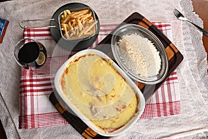 bolognese lasagna baked with cheese ham red sauce spices and meat with french fries and rice