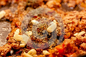 Bolognese ragout in a frying pan with wooden spoon, authentic recipe, close-up