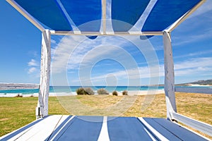 Bolonia Beach framed from a wooden bed with surf boards photo