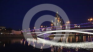 Bolshoy Ustinsky bridge over the Moscow river at night against the backdrop of a high-rise building on Kotelnicheskaya embankment.