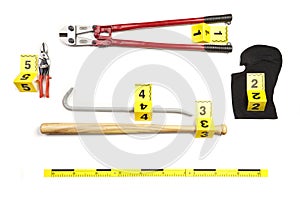 Bolt cutters, baseball bat, balaclava, pliers and other props of burglary documented as evidence of crime on white background