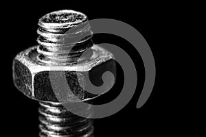 Bolt with nut black and white photo macro isolated on black background