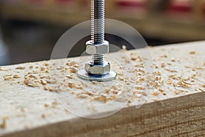 Bolt and nut twisted into a wooden board