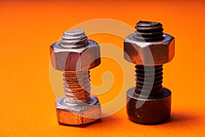 Bolted connecting elements on orange background close-up