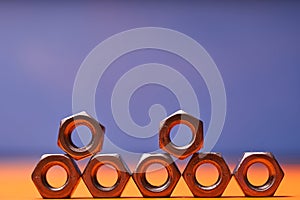 Bolted connecting elements on orange, blue background close-up