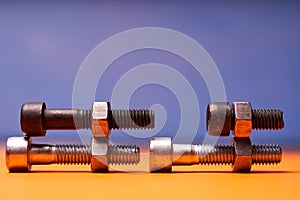 Bolted connecting elements on orange, blue background close-up