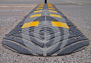 Bolted down speed bump made of rubber on asphalt road