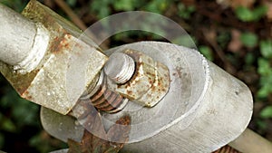 Bolted suspension bridge fastener with rusty corroded nuts.