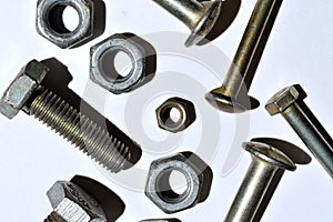 bolts and nuts of different sizes lie on a white background.