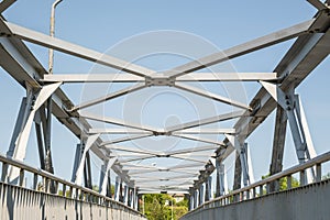 Bolts and nuts on metal plates of steel structure of heavy duty straight crossbar of frame and bridge support