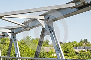 Bolts and nuts on metal plates of steel structure of heavy duty straight crossbar of frame and bridge support