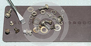 Bolts, nuts, washers on a black magnetic Mat