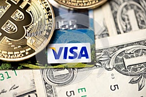 Bitcoin on Visa credit card and one dollar banknotes. Digital money with plastic money. Banknotes