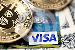 Bitcoin on Visa debit card and one dollar banknotes. Digital money with plastic money. Banknotes