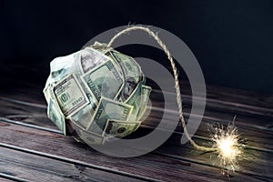 Bomb of money hundred dollar bills with a burning wick. Little time before the explosion. Concept of financial crisis