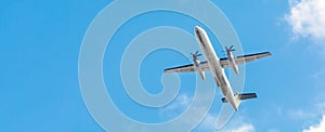 Bombardier Dash Turboprop aircraft in clear blue sky. Passenger Transportation. Aviation. Air business. Free space for text