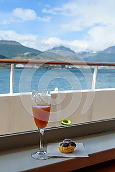 Bon Voyage drink and pastry, looking out over deck and railing from inside cruise ship