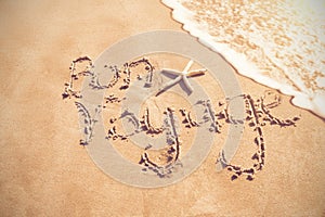 Bon voyage written on sand