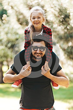 The bond between father and daughter. A child on dad`s shoulders, a fun pastime together