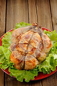 Bondage shibari roasted chicken with salad leaves on red plate o