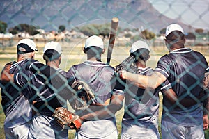 Bonded together by baseball. Rearview shot of a group of young men standing together in solidarity at a baseball game.