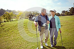 Bonding on the golf course. a smiling senior couple enjoying a day on the golf course.