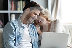 Bonding happy two generations family laughing, watching funny video online.