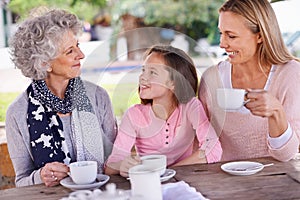 Bonding time for the girl. Shot of three generations of the woman of the women of a family having tea outside.