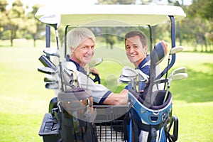 Bonding together on the golf course. Golfing companions on the golf course in a golf cart.