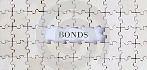 BONDS .Business concept. White puzzle pieces with different phrases on the white background, top view