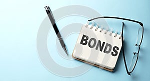 BONDS text written on a notepad on the blue background