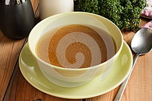 Bone broth made from beef, served in a green soup bowl