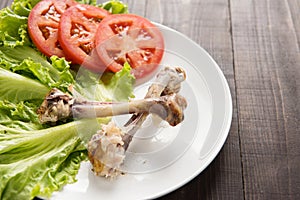 Bone chicken and vegetable on wooden background.