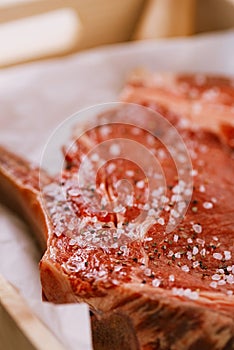 Bone-in Rib eye Steak steak on paper and wooden table