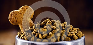 Bone-shaped dog biscuits with pet food, spot focus