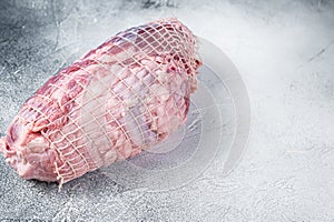Boneless Leg of Lamb meat on butcher table. White background. Top view. Copy space