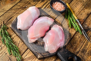 Boneless Raw Chicken thigh fillet. Wooden background. Top view